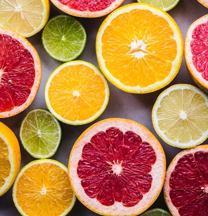 flat lay photography of sliced pomegranate, lime, and lemon