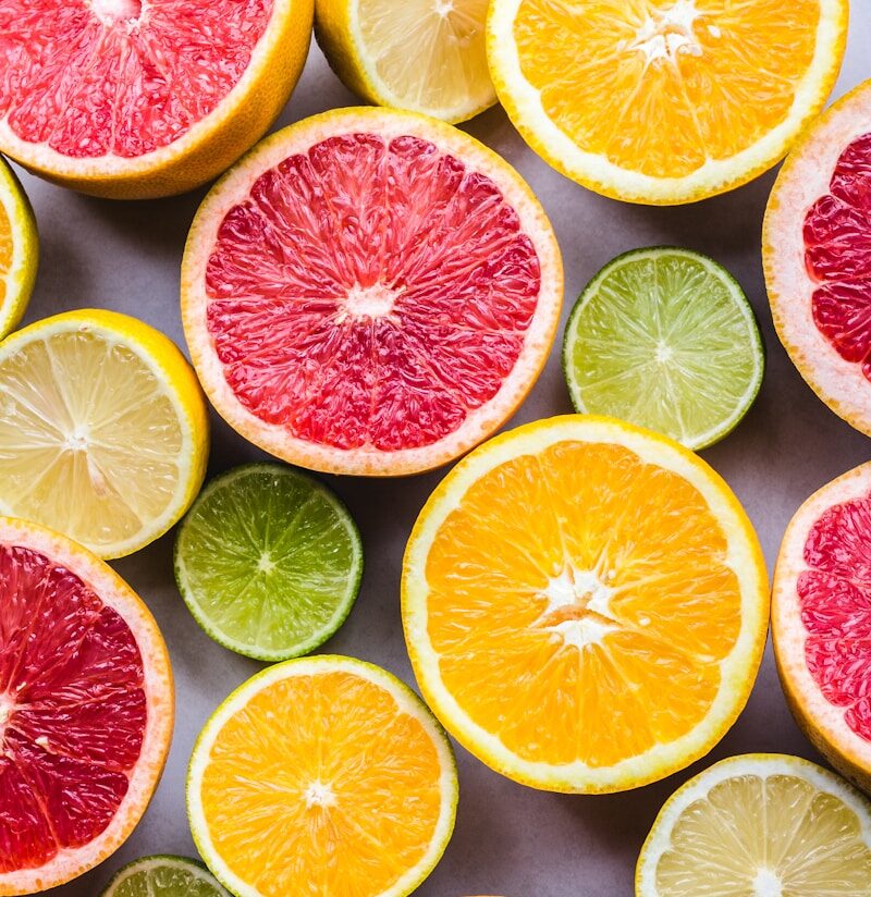 flat lay photography of sliced pomegranate, lime, and lemon