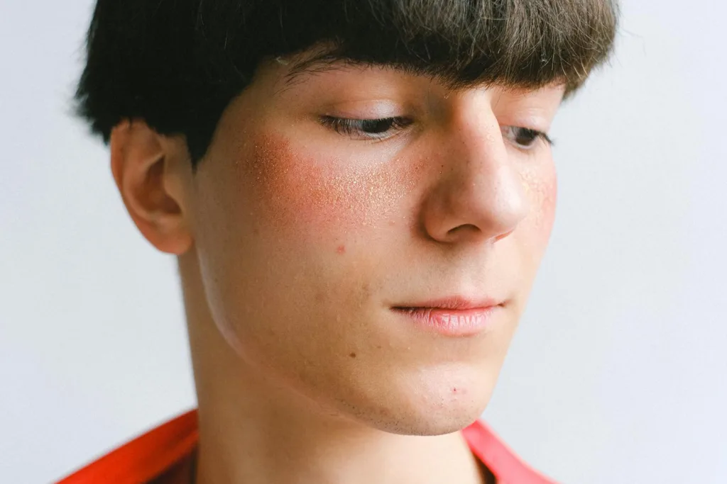 Portrait of a young man with freckles in a soft light setting.